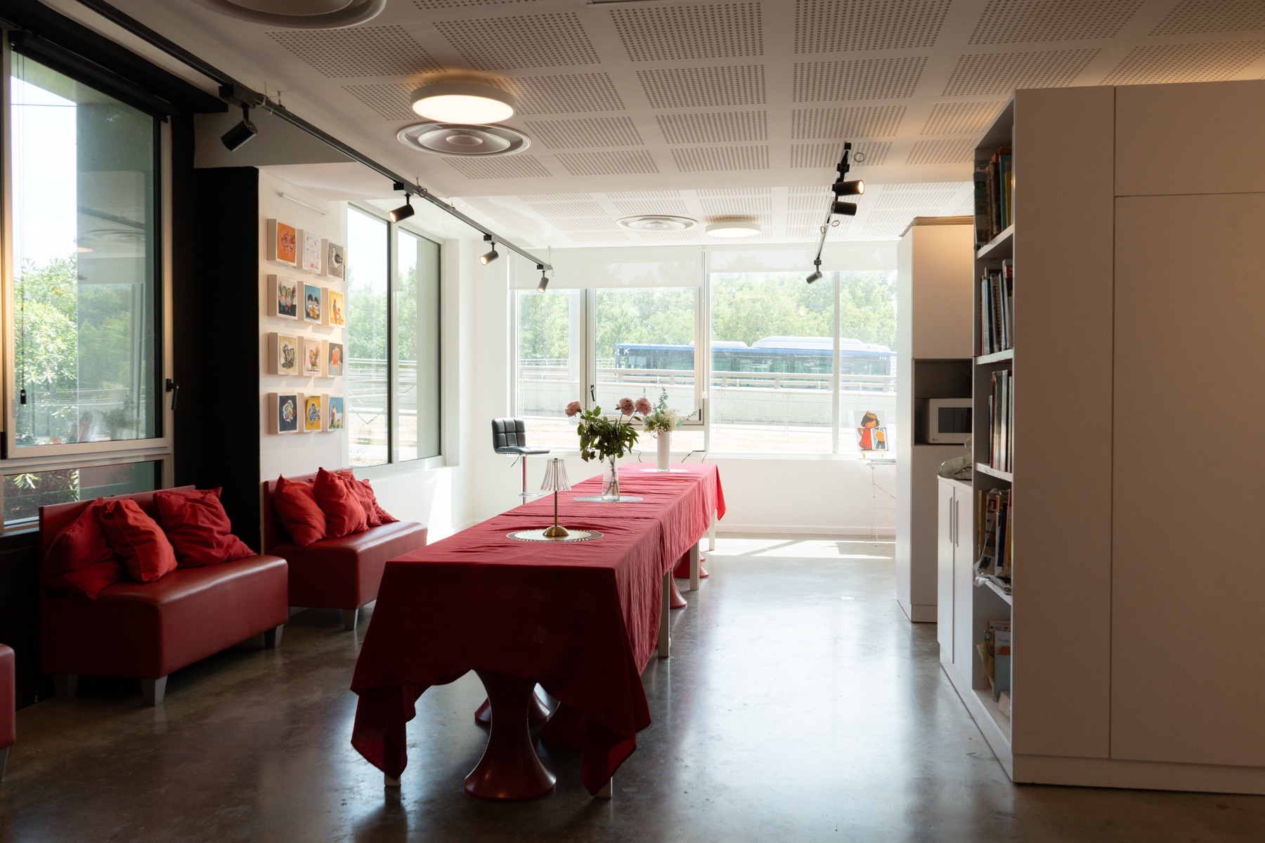 L’espace blanc en enfilade : la grande table, les banquettes et les baies vitrées sur toute la longueur.